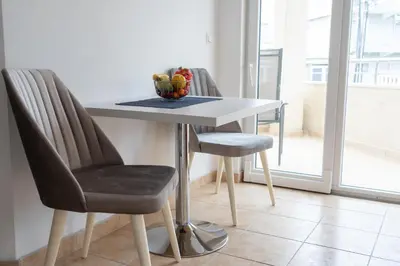 a table with two chairs and a bowl of fruit on it at Apartments Sejla in Ulcinj