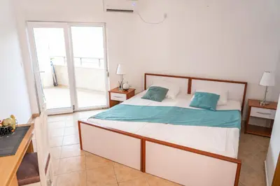 a bedroom with a bed with blue pillows on it at Apartments Sejla in Ulcinj