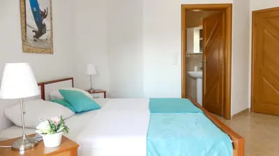 a bedroom with a white bed and a table with a lamp at Apartments Sejla in Ulcinj