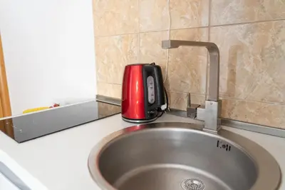 a red appliance sitting on top of a sink at Apartments Sejla in Ulcinj
