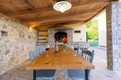 a dining room with a wooden table and a stone fireplace at Villa Forest & Blue in Kotor