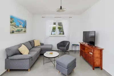 a living room with a couch and a tv at Villa Forest & Blue in Kotor