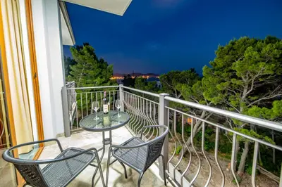 a patio with a table and chairs on a balcony at Green Pino Seaview Studios in Bar