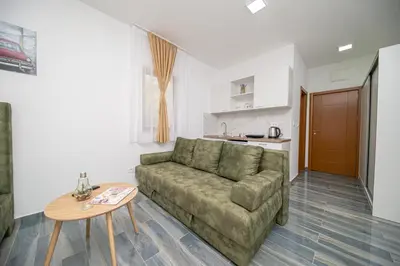 a living room with a couch and a table at Green Pino Seaview Studios in Bar