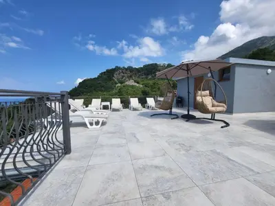 a patio with chairs and an umbrella on a building at Green Pino Seaview Studios in Bar