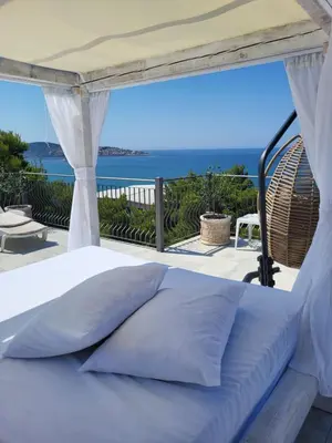 a white bed with a view of the ocean at Green Pino Seaview Studios in Bar