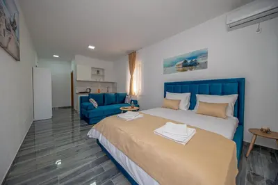 a bedroom with a blue bed and a blue couch at Green Pino Seaview Studios in Bar