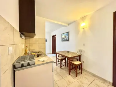 a kitchen with a sink and a table in it at The Four Fish in Petrovac na Moru