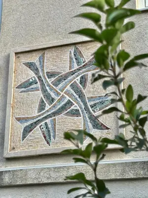 a mosaic on the side of a building with a plant at The Four Fish in Petrovac na Moru