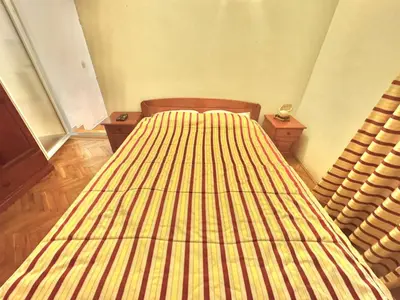 a bedroom with a bed with a striped bedspread at The Four Fish in Petrovac na Moru