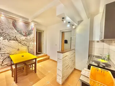 a kitchen with a yellow table and a counter at The Four Fish in Petrovac na Moru