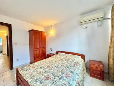 a bedroom with a bed and a wooden cabinet at The Four Fish in Petrovac na Moru