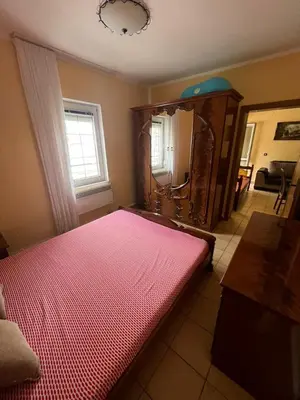 a bedroom with a red bed and a mirror at Apartman Sutomore in Sutomore