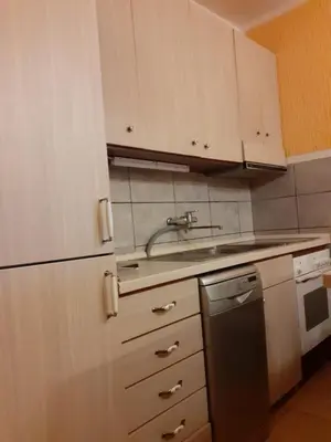 a kitchen with white cabinets and a sink and a dishwasher at Apartman Sutomore in Sutomore