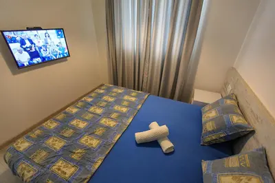 a bedroom with a bed and a tv on the wall at Apartments Sarić in Bar