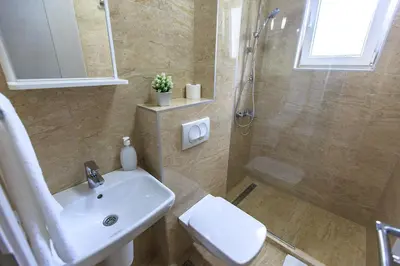 a bathroom with a sink and a shower at Apartments Sarić in Bar