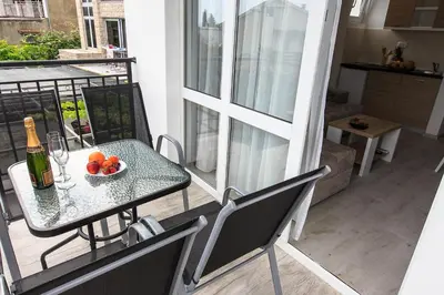 a table with a bottle of wine and fruit on a balcony at Apartments Sarić in Bar