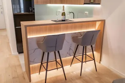 a kitchen with a bar with two chairs under it at Soho City A403 in Bar