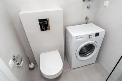 a bathroom with a toilet and a washing machine at Soho City A403 in Bar