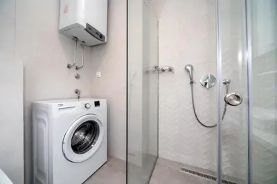 a bathroom with a washing machine and a shower at Soho City A403 in Bar