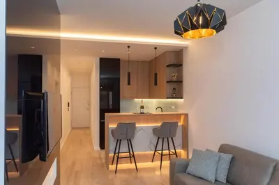 a kitchen and living room with a couch and a counter at Soho City A403 in Bar