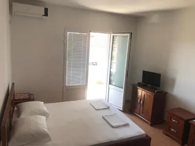 a bedroom with a bed and a tv and a window at Apartments ND in Bar