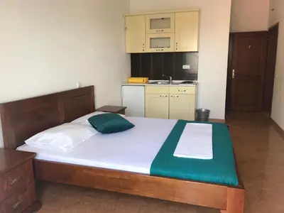 a large bed in a room with a kitchen at Apartments ND in Bar