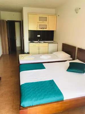 two twin beds in a room with a kitchen at Apartments ND in Bar