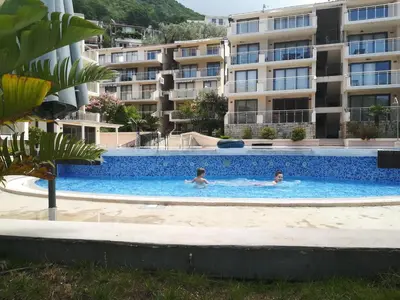 two people swimming in a swimming pool in a building at Blue Horizon Lux Apartment with Pool in Sveti Stefan