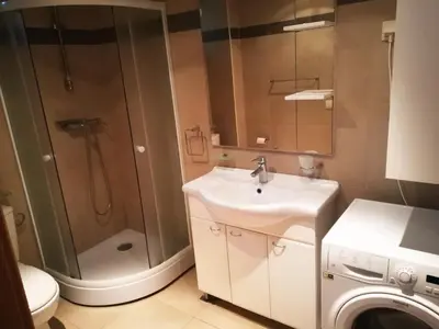 a bathroom with a sink and a shower and a washing machine at Blue Horizon Lux Apartment with Pool in Sveti Stefan