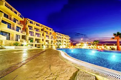 a swimming pool in front of a hotel at night at Blue Horizon Lux Apartment with Pool in Sveti Stefan