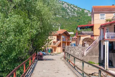 a street in a village with houses and a mountain at Pristan Apartments in Dodoši