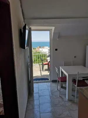 a room with a table and a view of the ocean at Apartman Kosta in Utjeha