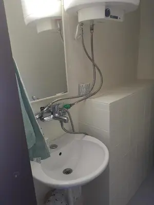 a bathroom with a white sink and a mirror at Apartman Kosta in Utjeha