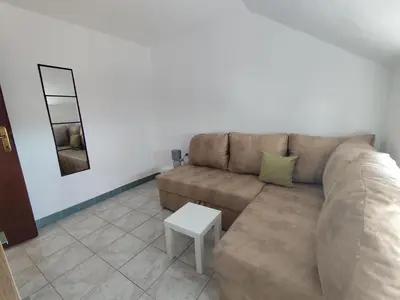 a living room with a couch and a table at Apartman Kosta in Utjeha