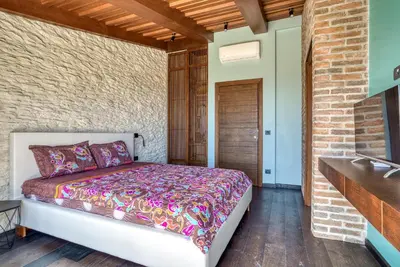 a bedroom with a bed and a brick wall at Vila Stari Mlin in Ivanovići