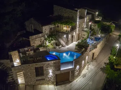 a building with a swimming pool at night at Vila Stari Mlin in Ivanovići