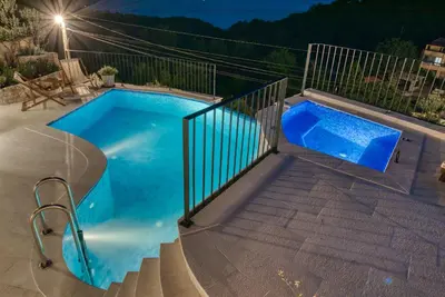 a small blue swimming pool with a metal fence at Vila Stari Mlin in Ivanovići