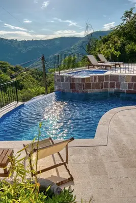 a swimming pool with a bench and mountains in the background at Vila Stari Mlin in Ivanovići