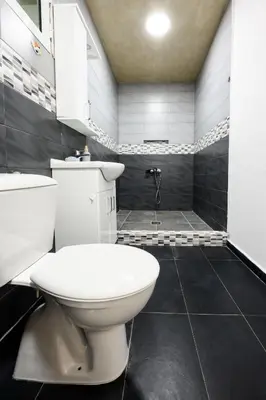 a bathroom with a white toilet and a shower at Apartmani Vukčević in Bar