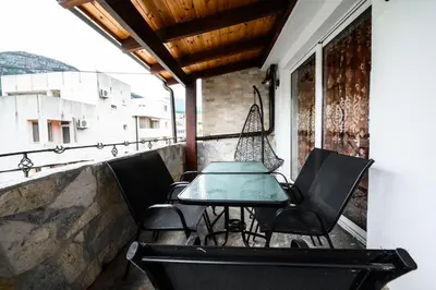a table and chairs on the balcony of a building at Apartmani Vukčević in Bar