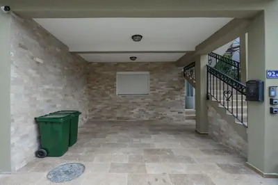 a hallway with a trash can and a brick wall at Apartmani Vukčević in Bar
