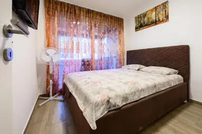 a bedroom with a bed and a window at Apartmani Vukčević in Bar