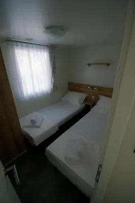 two beds in a small room with a window at HILLS RESORT Beach, Bungalows and Bar - Velika Plaza Ulcinj in Ulcinj