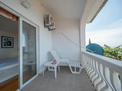 a white chair sitting on the balcony of a house at Villa Yovan Seaview in Dobra Voda