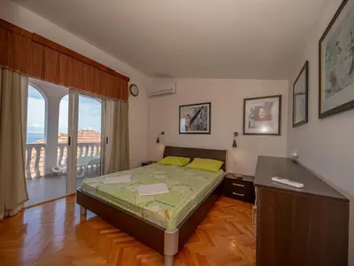 a bedroom with a bed and a balcony at Villa Yovan Seaview in Dobra Voda