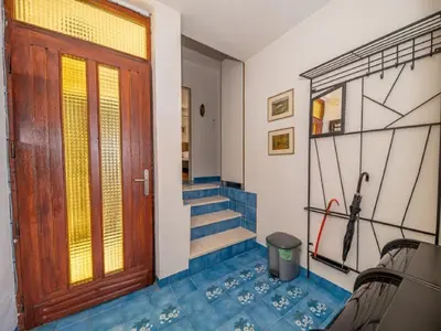 a hallway with a wooden door and stairs at Seaview Bosco Apartment in Dobra Voda