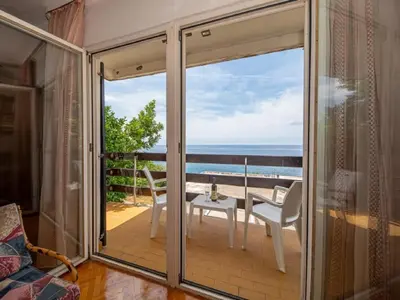 a room with a balcony with a view of the ocean at Seaview Bosco Apartment in Dobra Voda