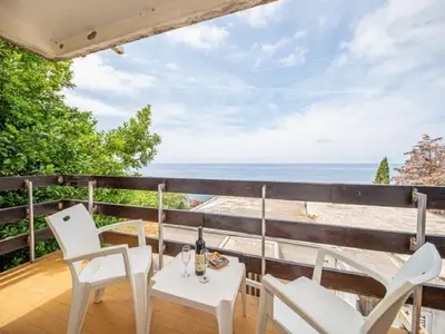 a balcony with a table and chairs and the ocean at Seaview Bosco Apartment in Dobra Voda