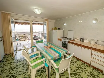 a kitchen with a table and chairs and a kitchen with a view at Seaview Bosco Apartment in Dobra Voda